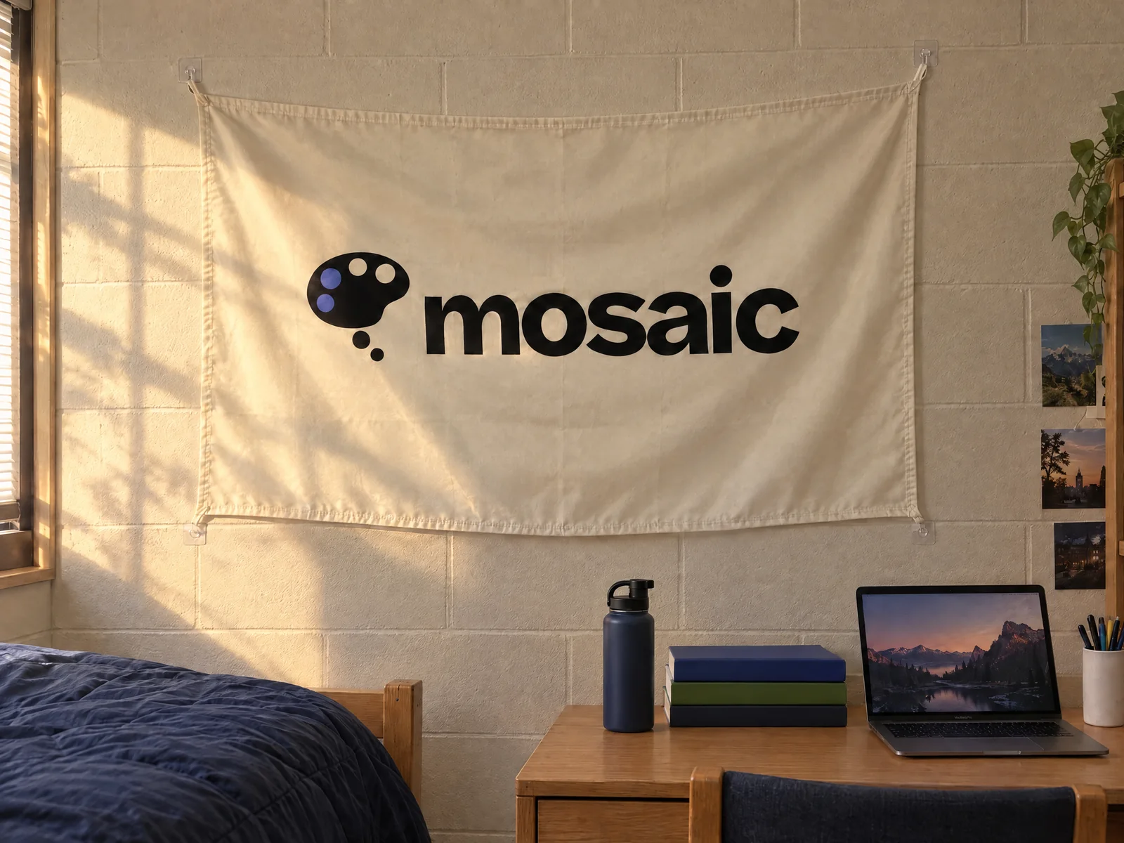 A Mosaic logo flag hanging on a dorm room wall above a desk
